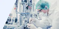 A man wearing a cleanroom suit working on a manufacturing line