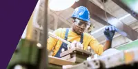A manufacturing worker working on a piece of machinery 