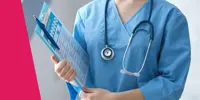 A close-up of a person wearing scrubs and holding a clipboard