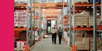 Two workers walking in a large warehouse