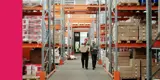 Two workers walking in a large warehouse